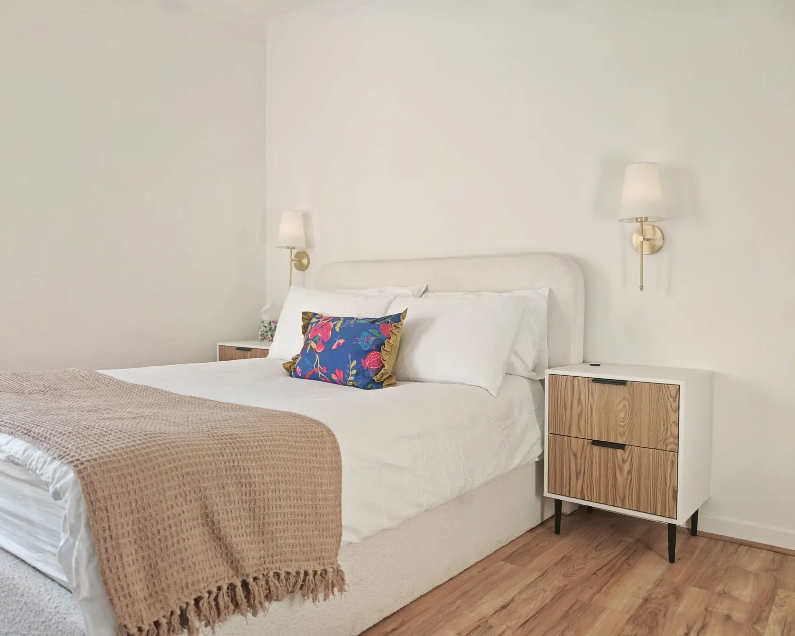 Double bedroom at Dhuha Retreats with a white bed, wooden bedside table and wall lights