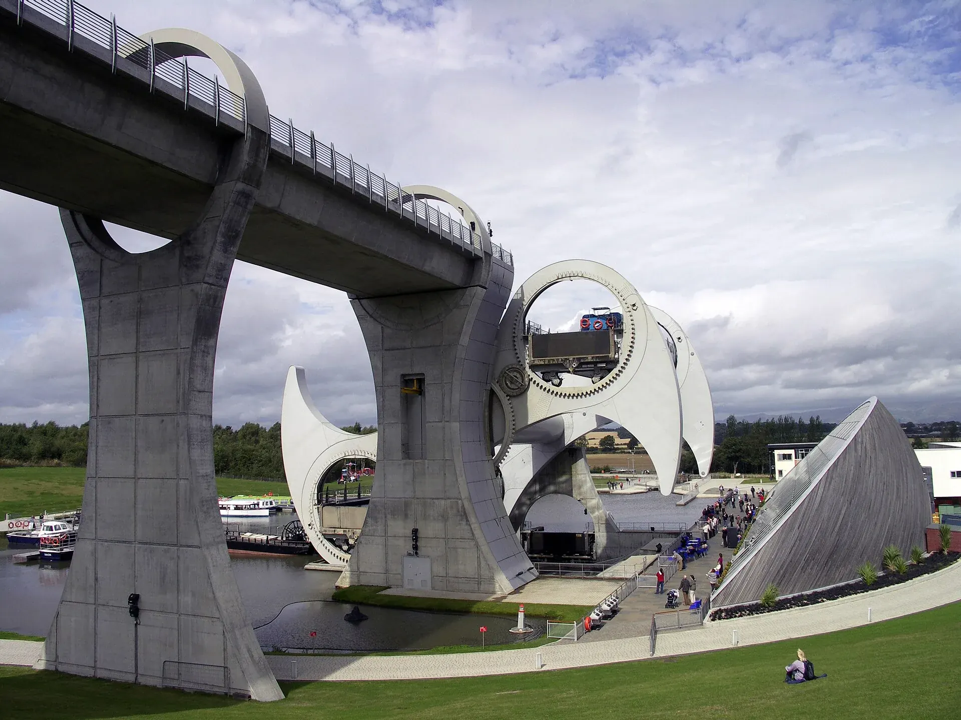The Falkirk Wheel rotating boat lift beside its aqueduct and green lawns