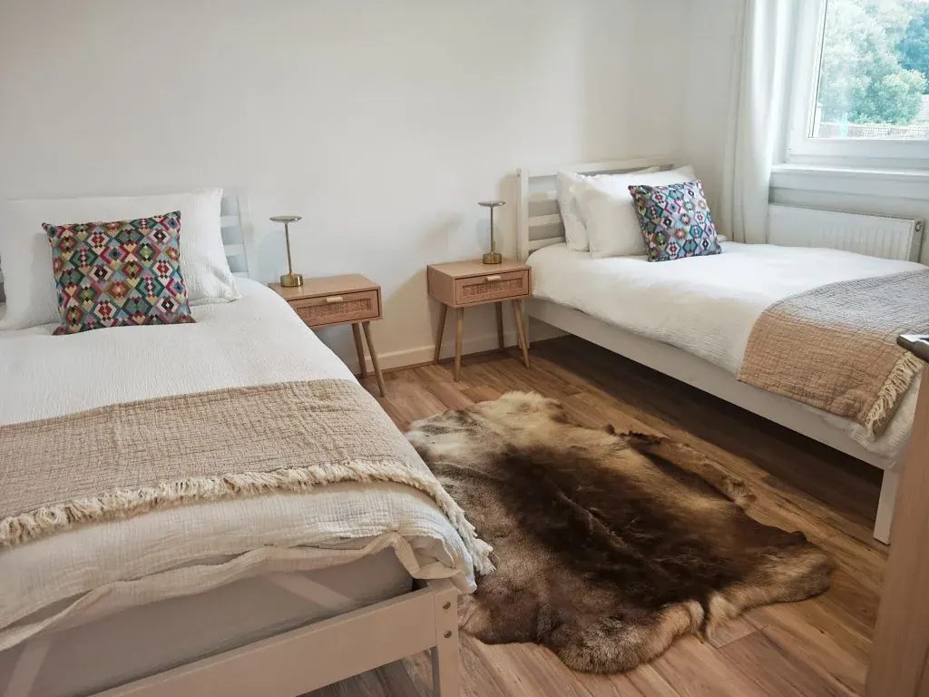Twin bedroom at Dhuha Retreats with two single beds, patterned cushions and a window